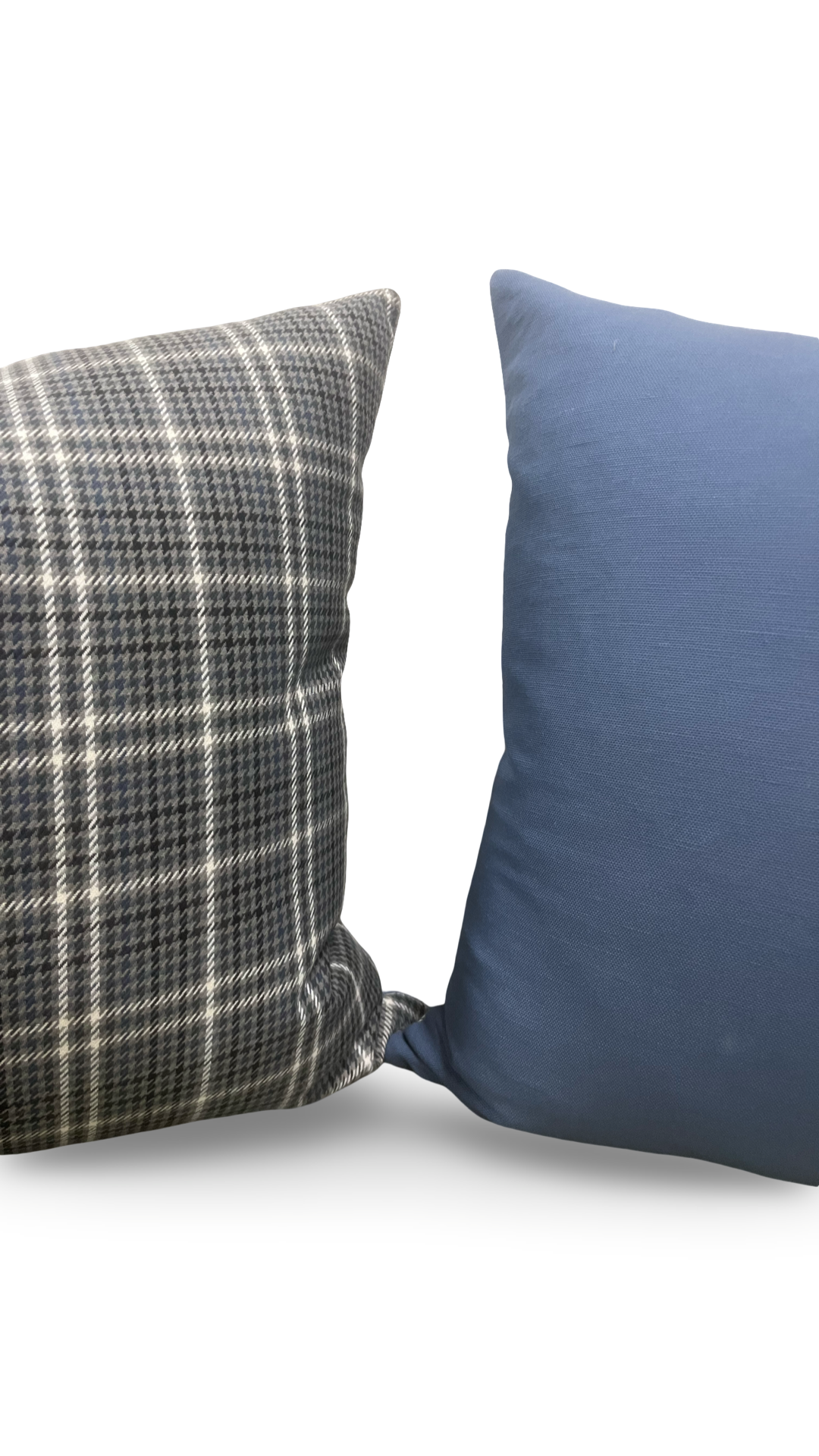 Two pillows, one plaid and one solid blue, on a white background