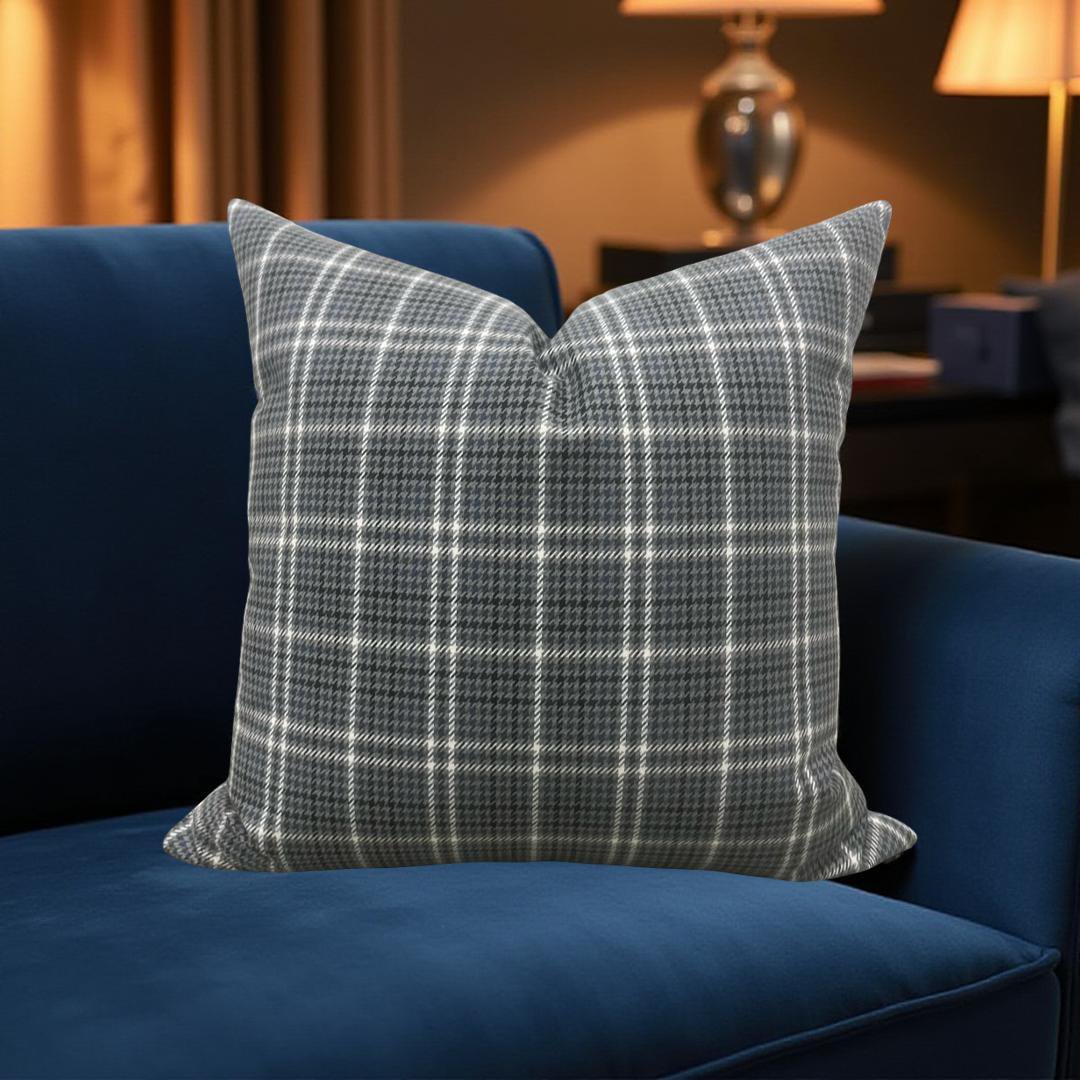 Plaid pillow on a blue couch in a cozy room with lamps.