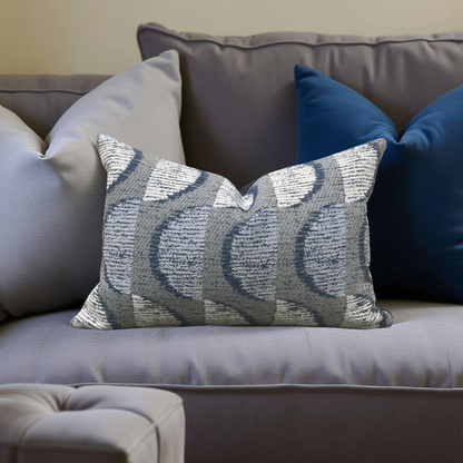 Gray and blue patterned pillow on a gray sofa with other pillows.