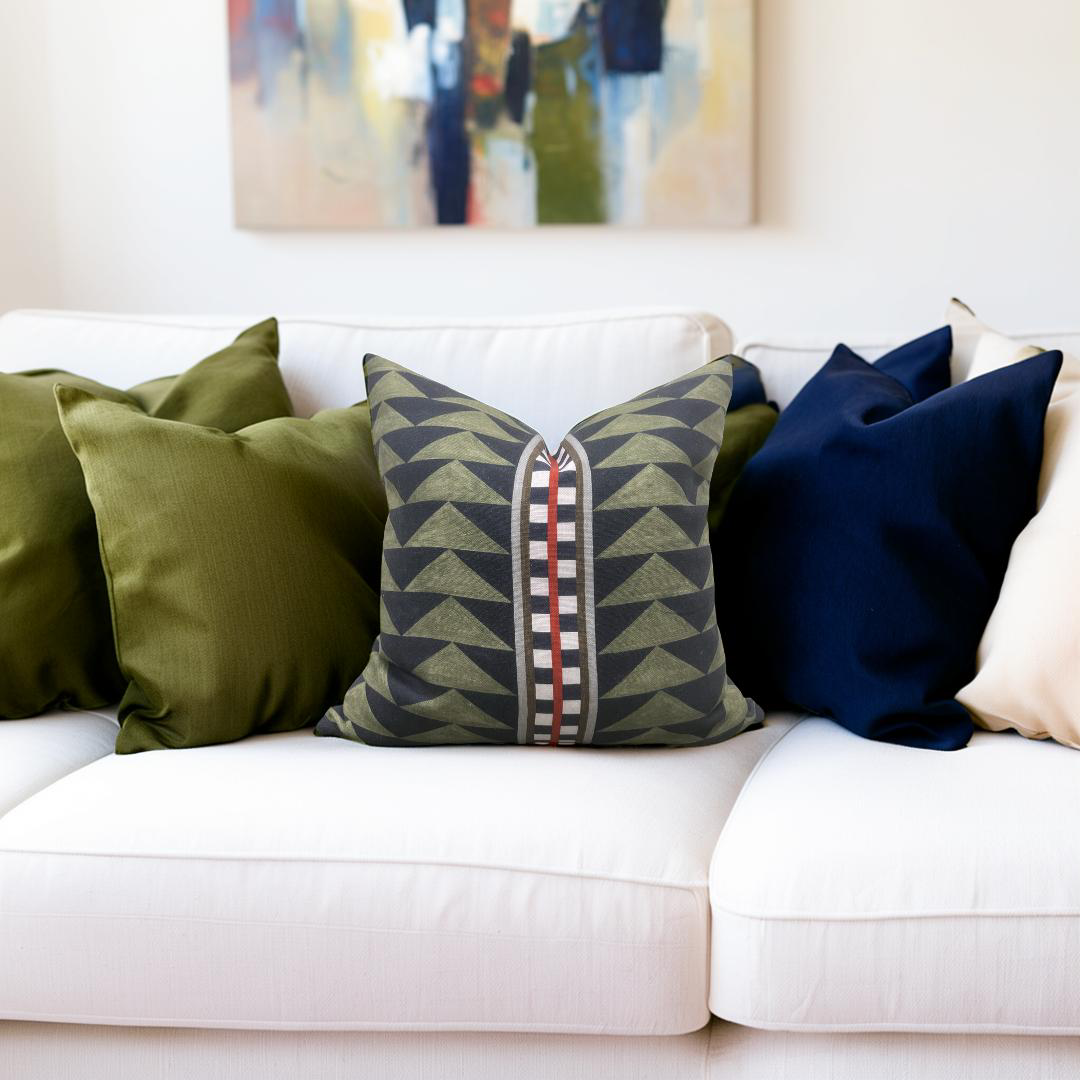 White sofa with colorful pillows and a painting in the background