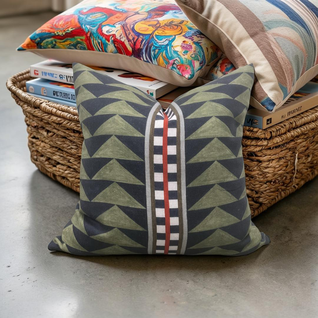 Geometric patterned pillow on a concrete floor with a wicker basket and books in the background.