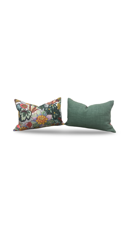 Two decorative pillows, one with floral pattern and one solid green, on a white background.