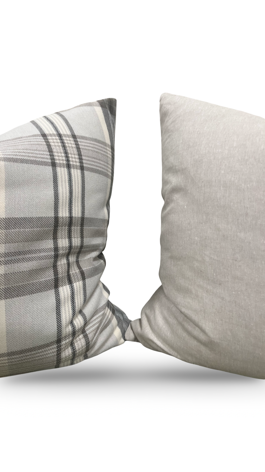 Two pillows, one plaid and one solid gray, on a white background