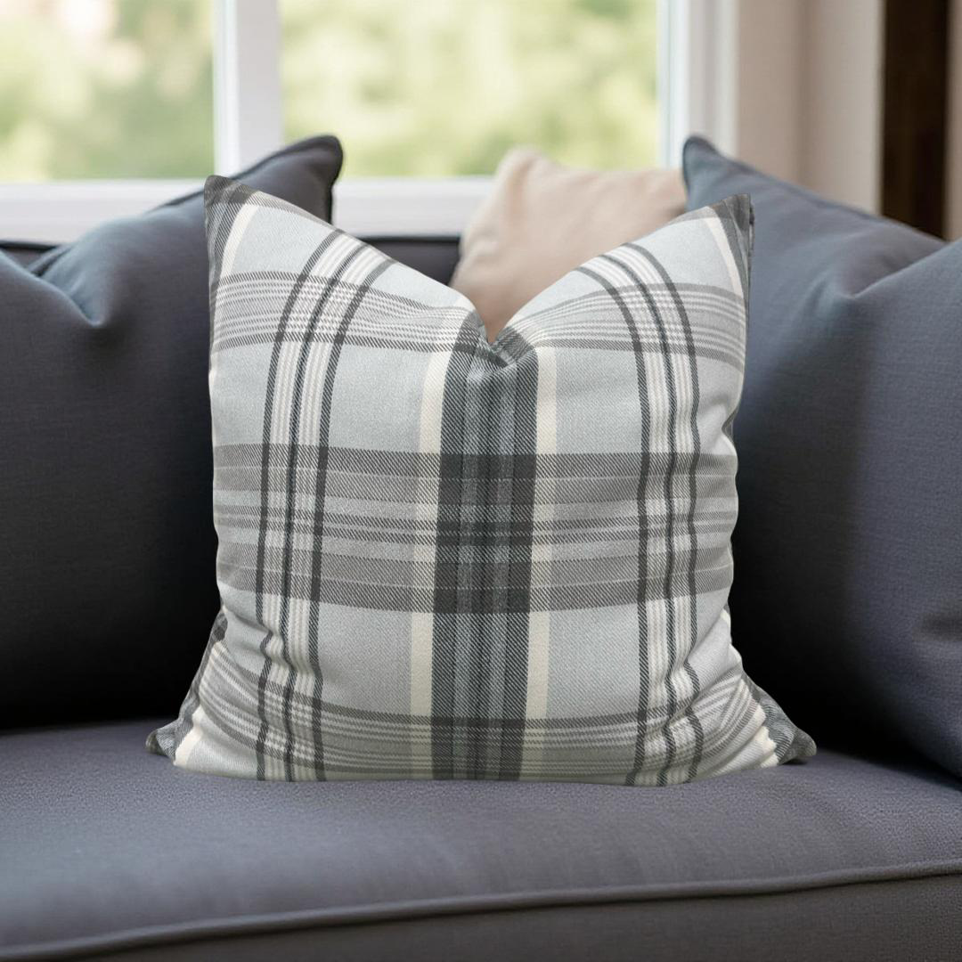 Plaid pillow on a gray sofa with a blurred background