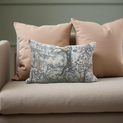 Decorative pillow with nature-themed design on a beige sofa against a neutral wall.