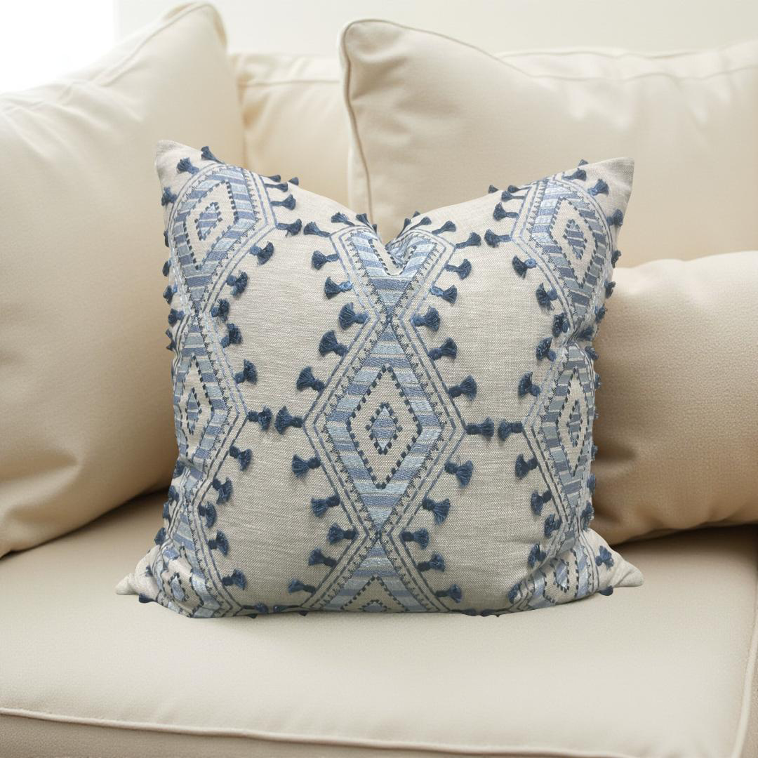 Decorative pillow with blue geometric pattern on a beige sofa