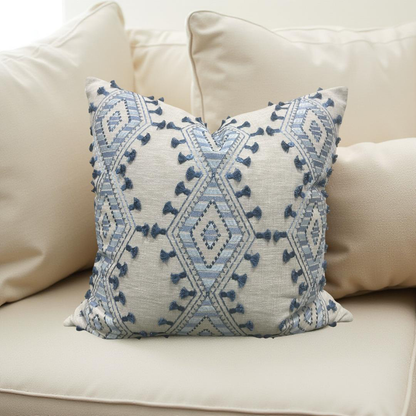 Decorative pillow with blue geometric pattern on a beige sofa