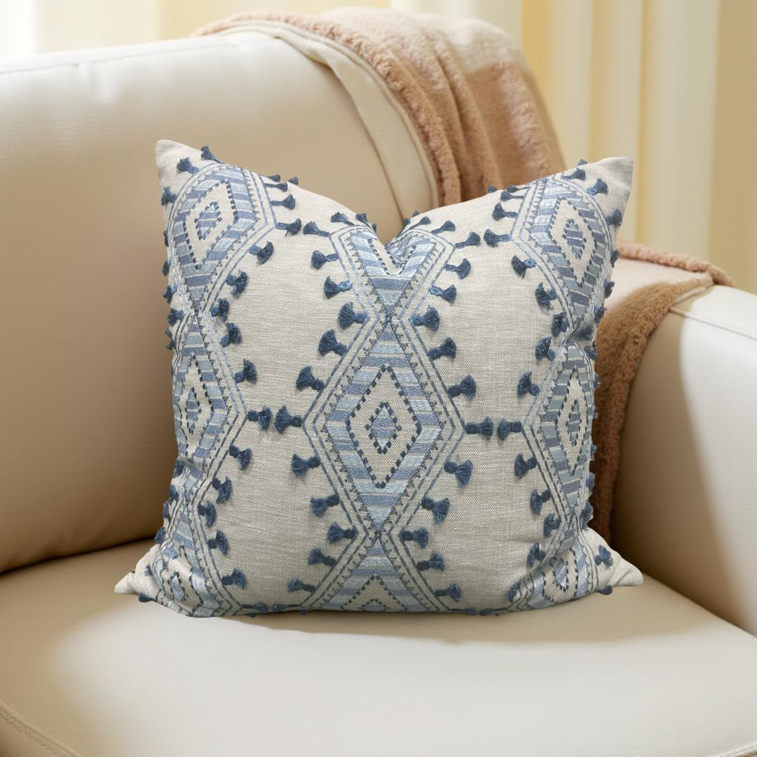 Decorative pillow with blue geometric pattern on a beige sofa