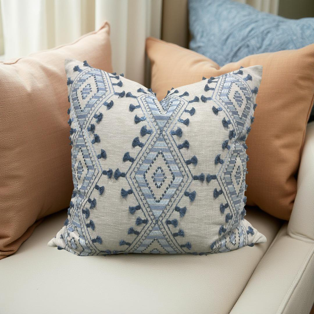 Decorative pillow with blue geometric pattern on a beige sofa