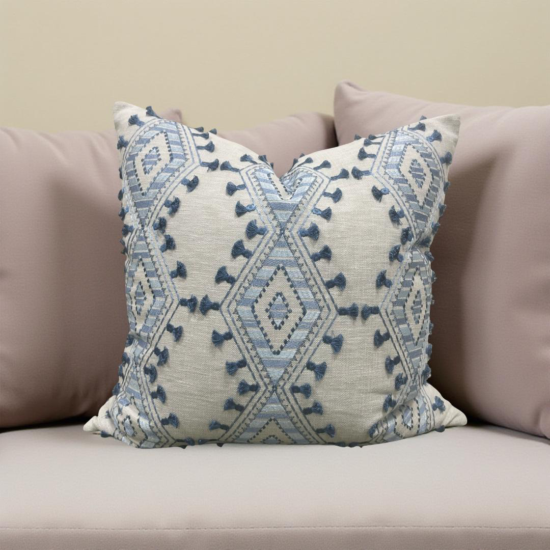 Decorative pillow with blue geometric pattern on a beige couch