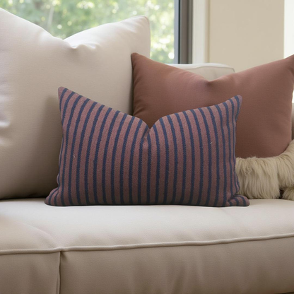 Striped pillow on a beige sofa with a blurred window background