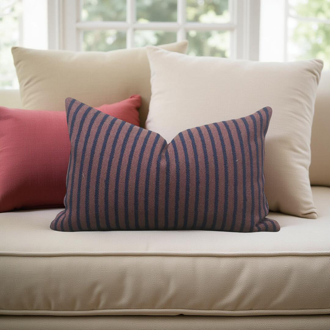 Striped pillow on a beige sofa with a blurred window background