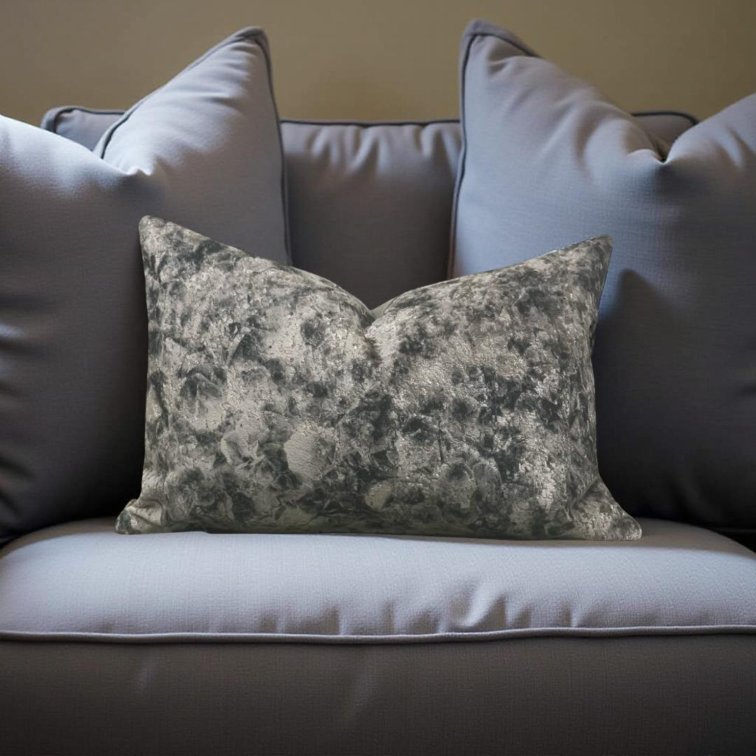 Floral patterned pillow on a sofa with other pillows in the background