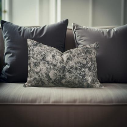 Gray floral pillow on a beige sofa with a neutral background