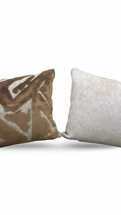 Two pillows, one with a pattern and one plain, on a white background