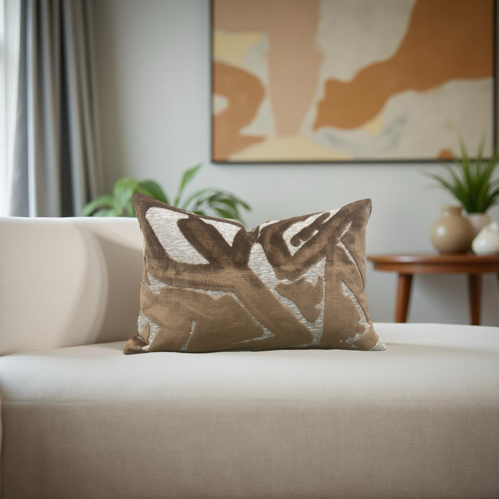 Decorative pillow on a beige sofa with a abstract painting in the background