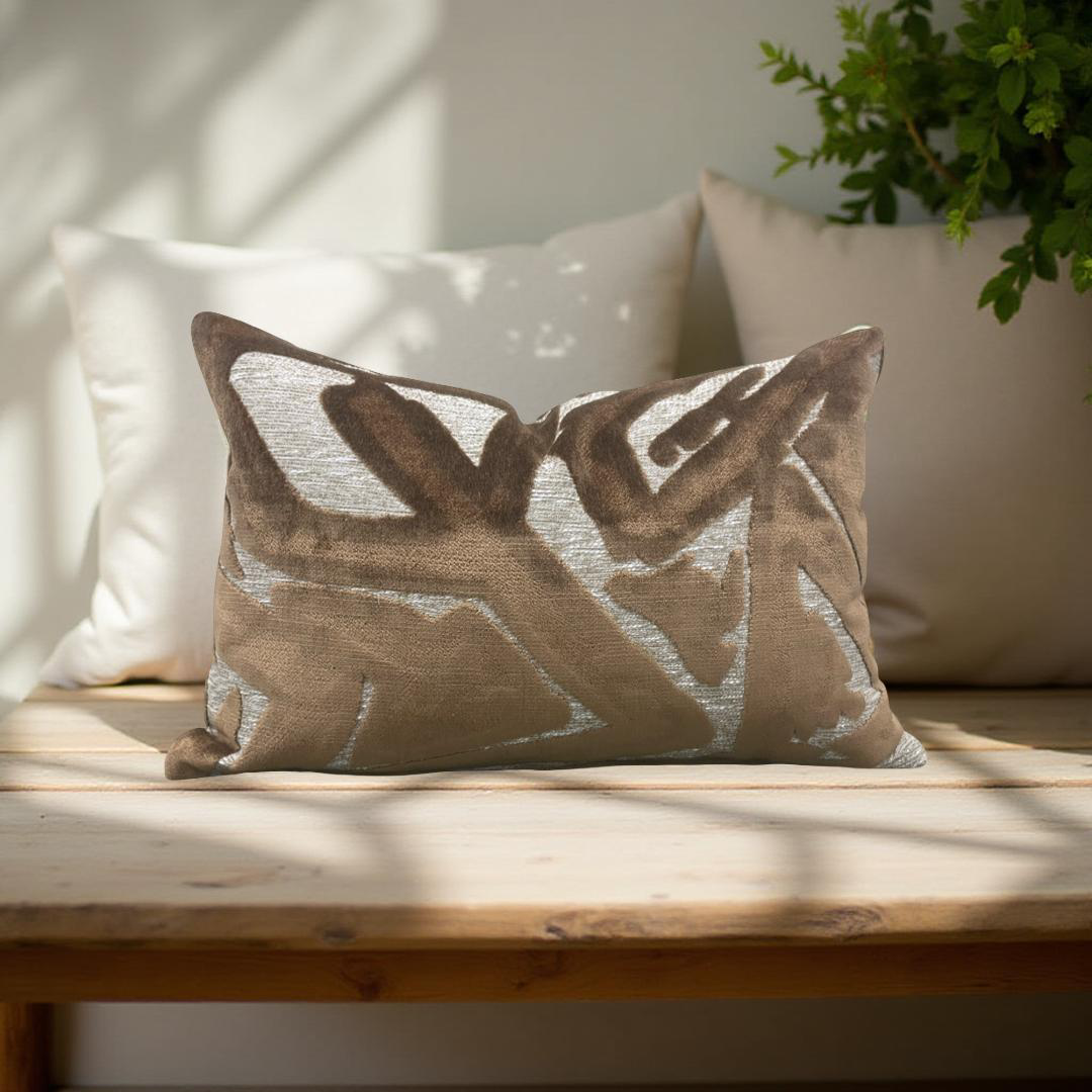 Decorative pillow with geometric pattern on a wooden bench with a plant in the background