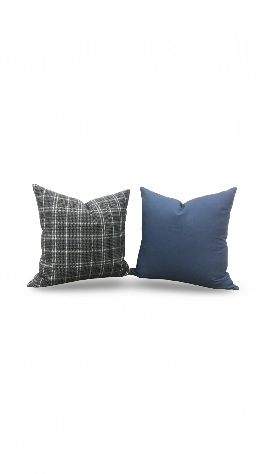 Two pillows, one plaid and one solid blue, on a white background