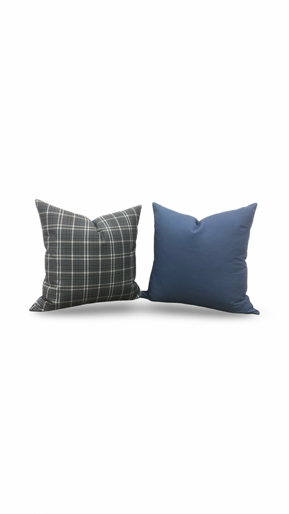 Two pillows, one plaid and one solid blue, on a white background