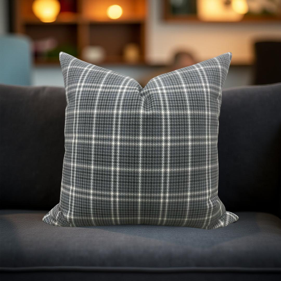 Plaid pillow on a dark sofa with a blurred background