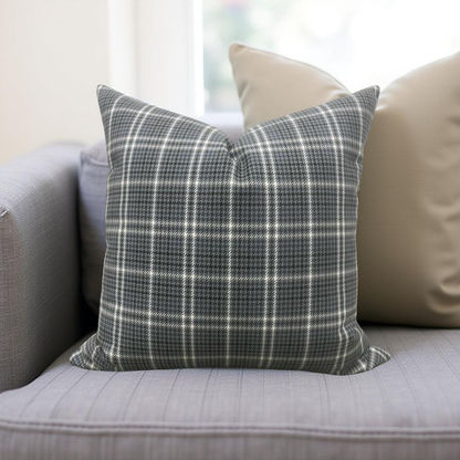 Plaid pillow on a gray sofa with a neutral background