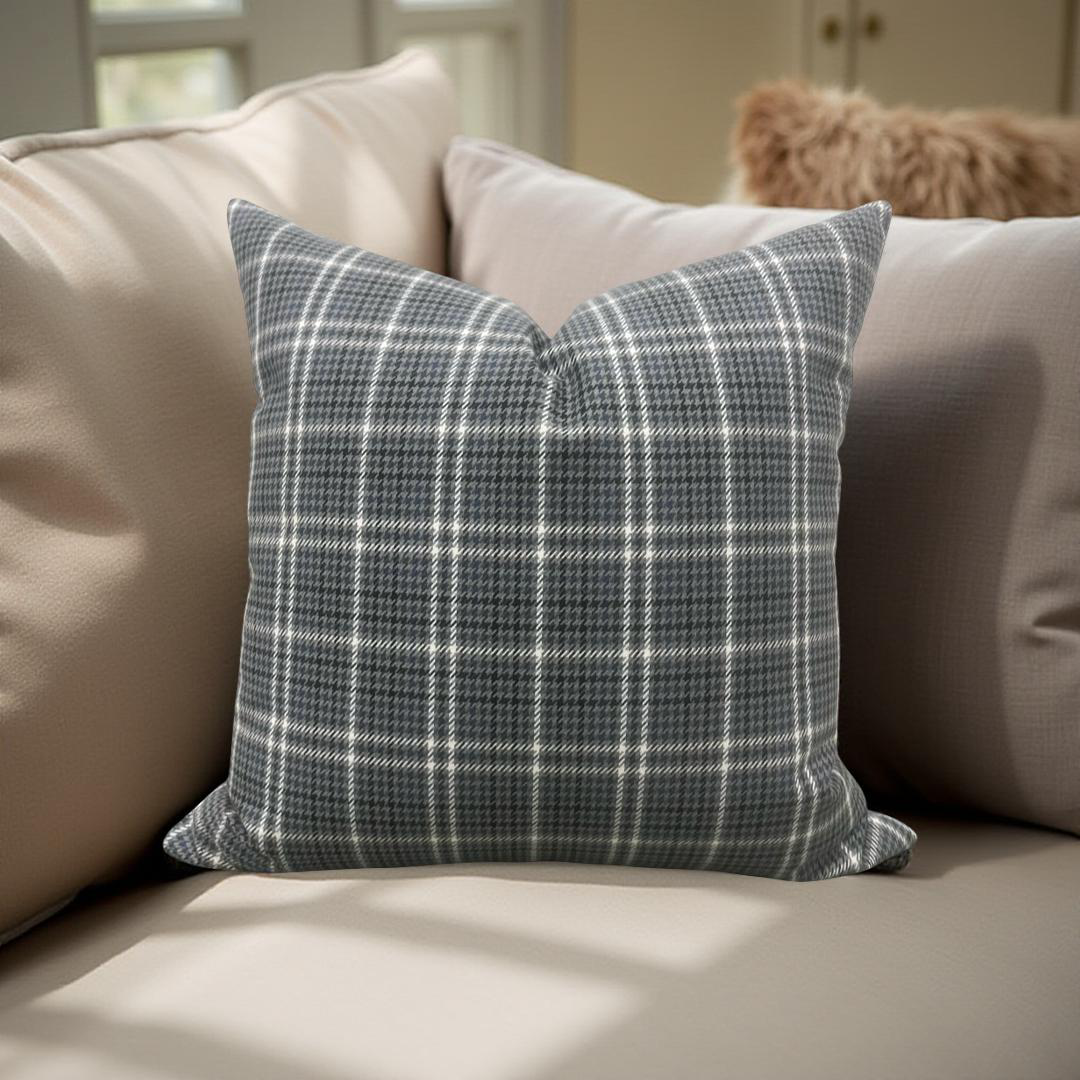 Plaid pillow on a beige sofa with a neutral background