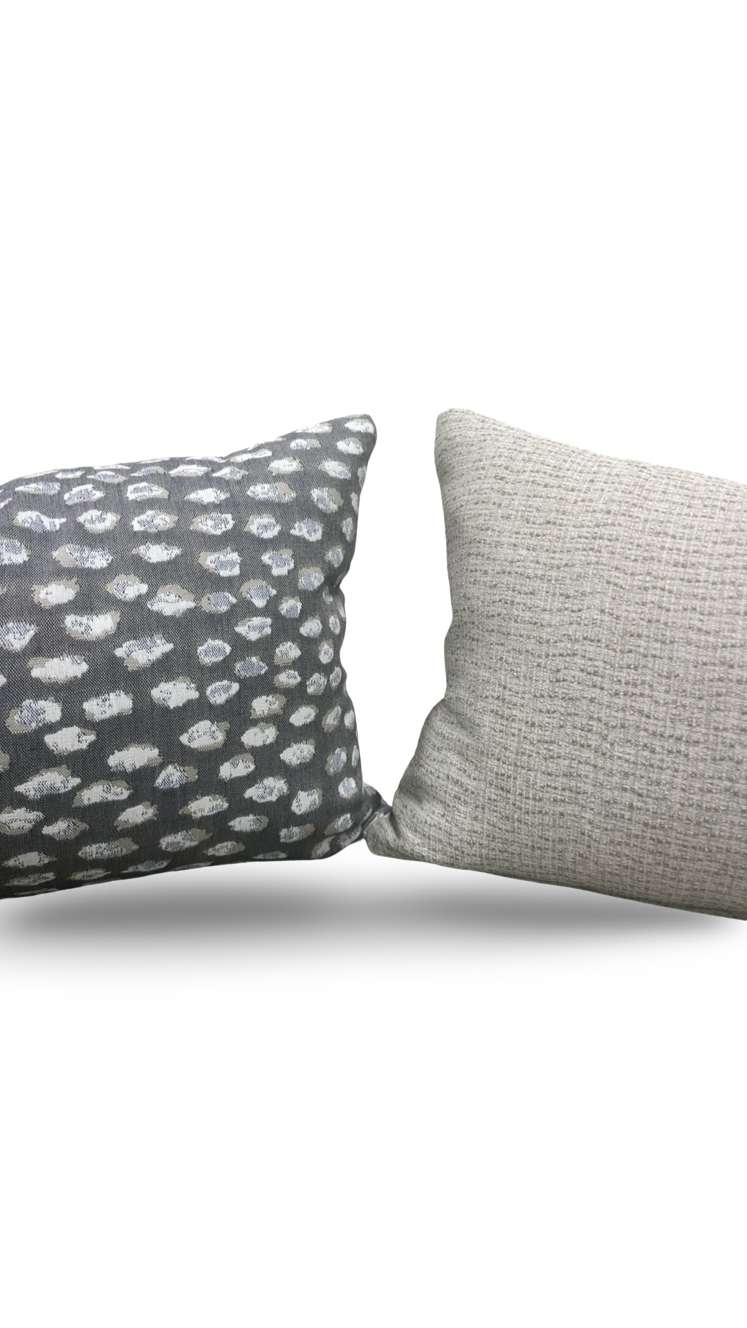 Two textured pillows, one with a pattern and one solid color, on a white background.
