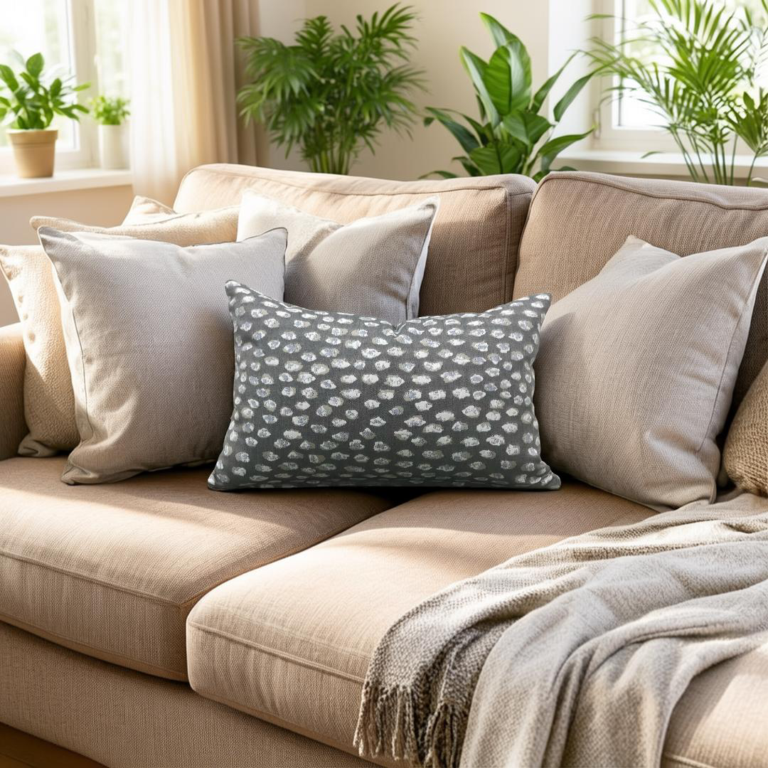 Beige sofa with decorative pillows and a blanket in a living room setting