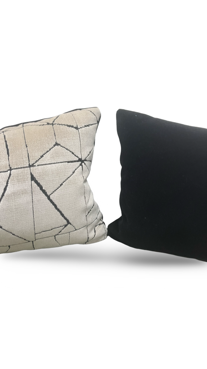 Two pillows, one with a geometric pattern and the other black, on a white background.