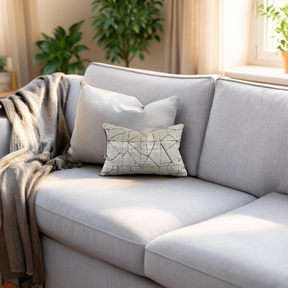 Gray sofa with decorative pillows and a blanket in a bright living room.