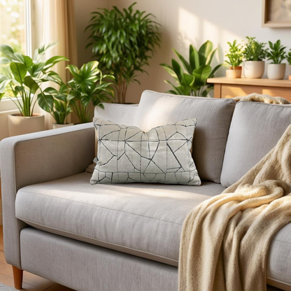 Gray sofa with a decorative pillow and blanket in a room with plants