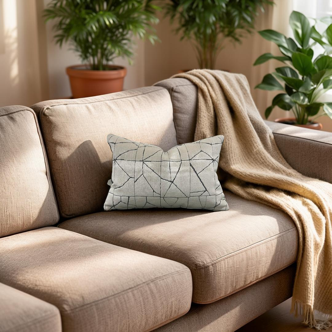 Beige sofa with a patterned pillow and blanket in a room with plants