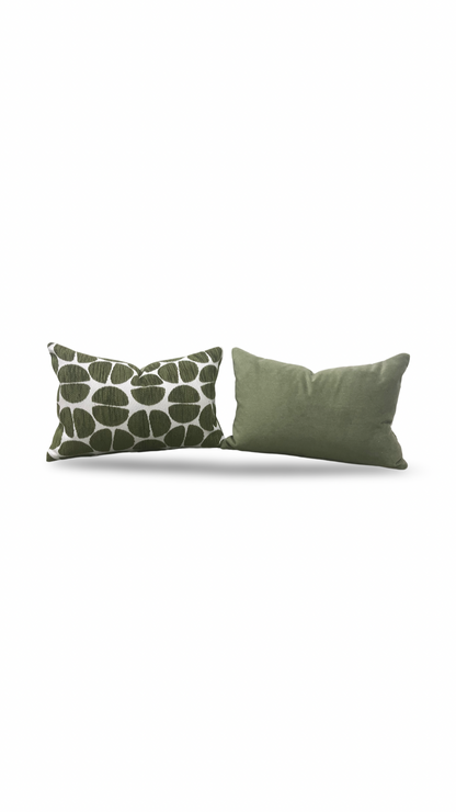 Two green pillows, one with a leaf pattern, on a white background