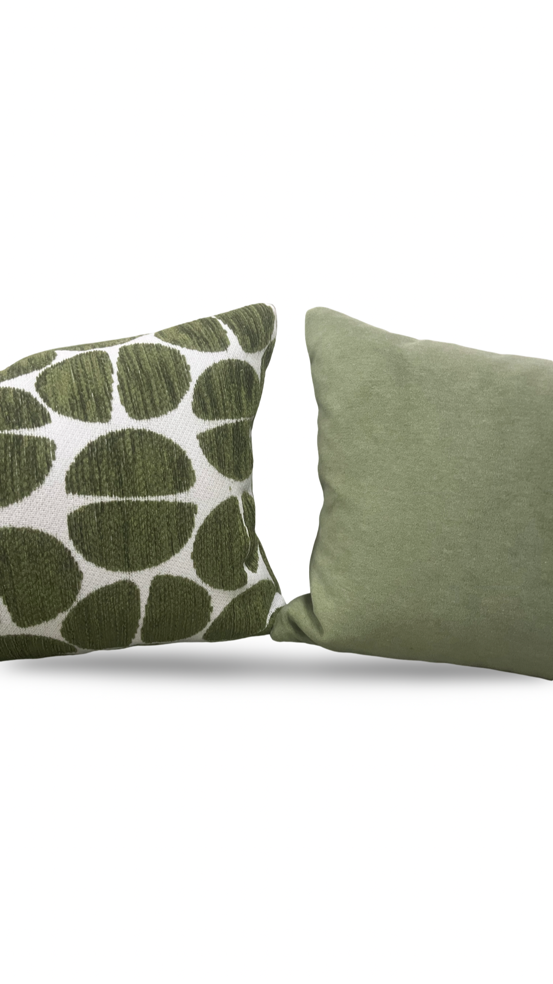 Two green pillows, one with a leaf pattern, on a white background