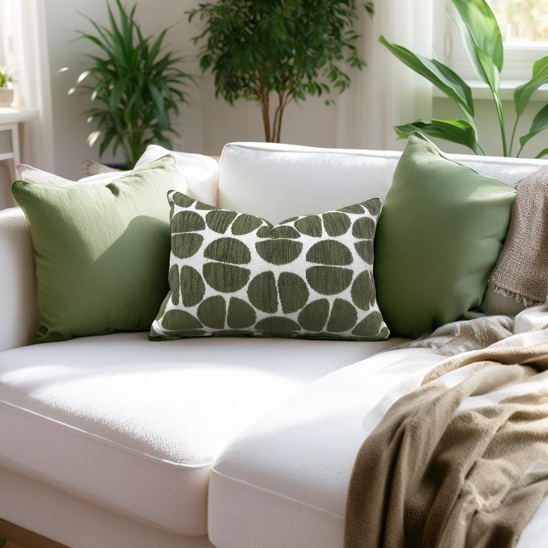 White sofa with green and patterned cushions in a bright room with plants