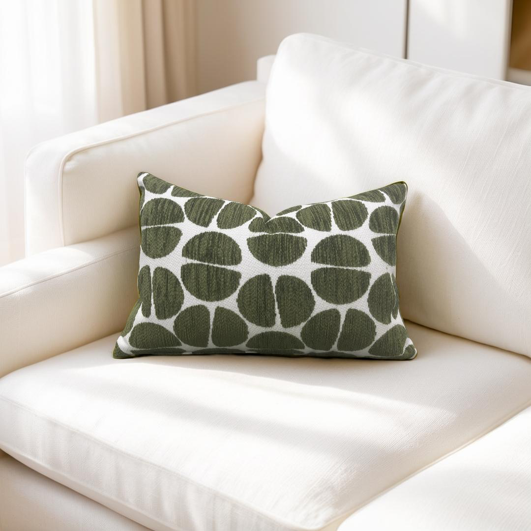 Green patterned pillow on a white couch