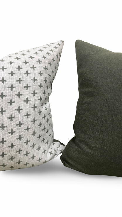 Two pillows, one with a geometric pattern and the other solid color, on a white background.