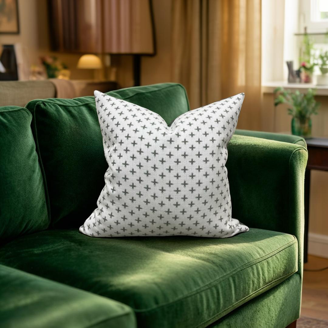 Green sofa with a patterned white pillow in a living room setting