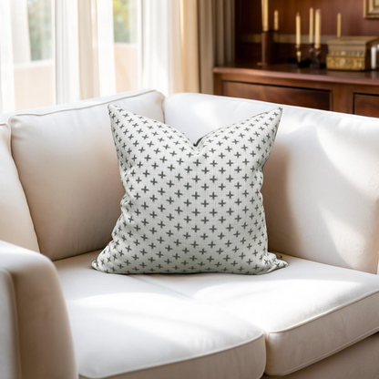 White sofa with a patterned gray pillow in a living room setting.