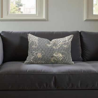 Gray sofa with decorative pillow featuring zebra pattern in a room with windows.