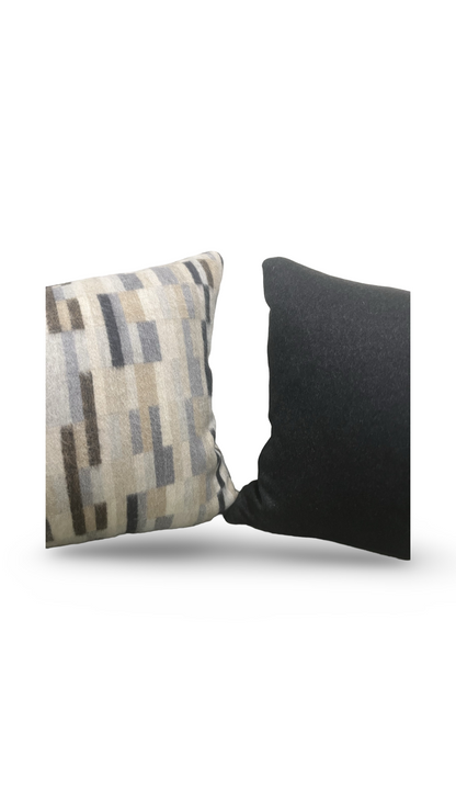 Two pillows, one with a patterned design and the other solid black, on a white background.