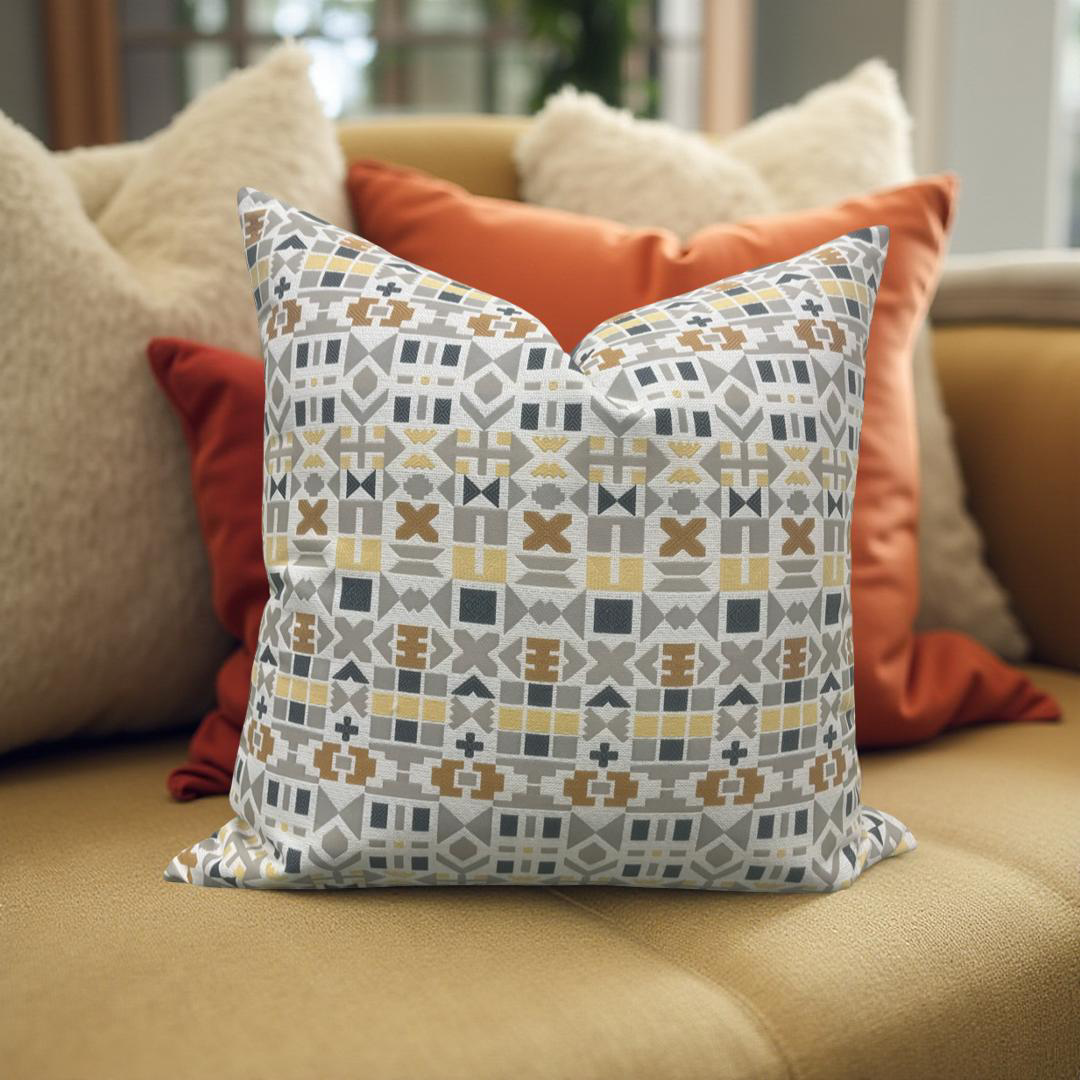 Patterned pillow on a couch with other pillows in the background