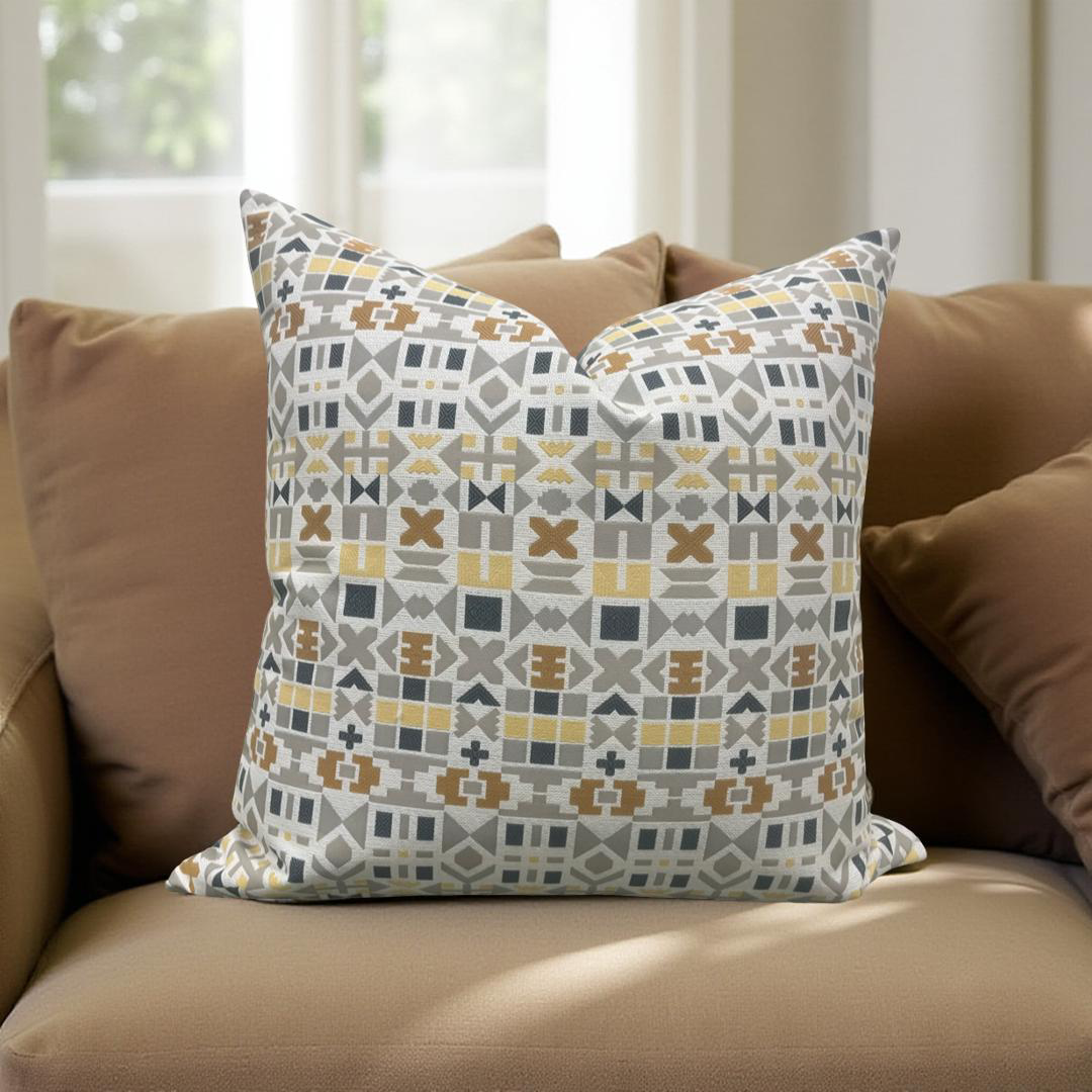 Patterned pillow on a brown sofa with a neutral background