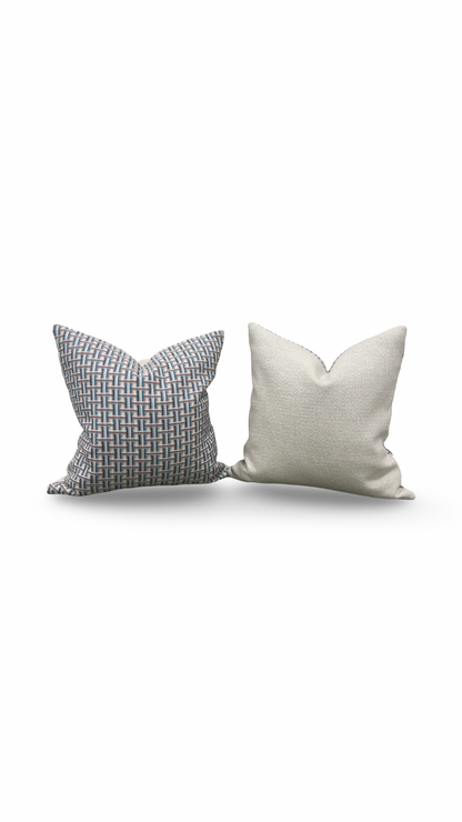 Two decorative pillows, one gray and one white, on a white background