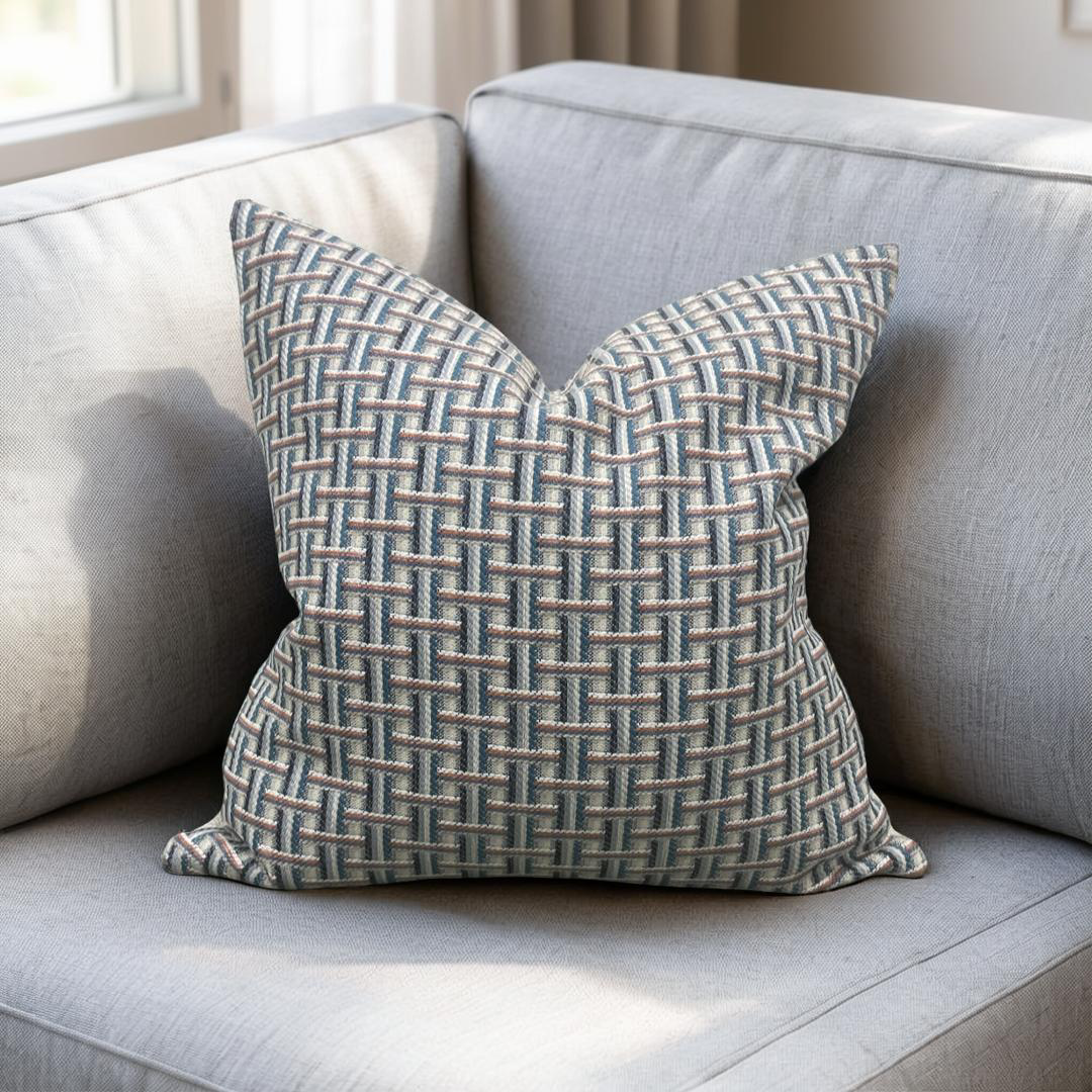 Patterned pillow on a light gray sofa with a neutral background