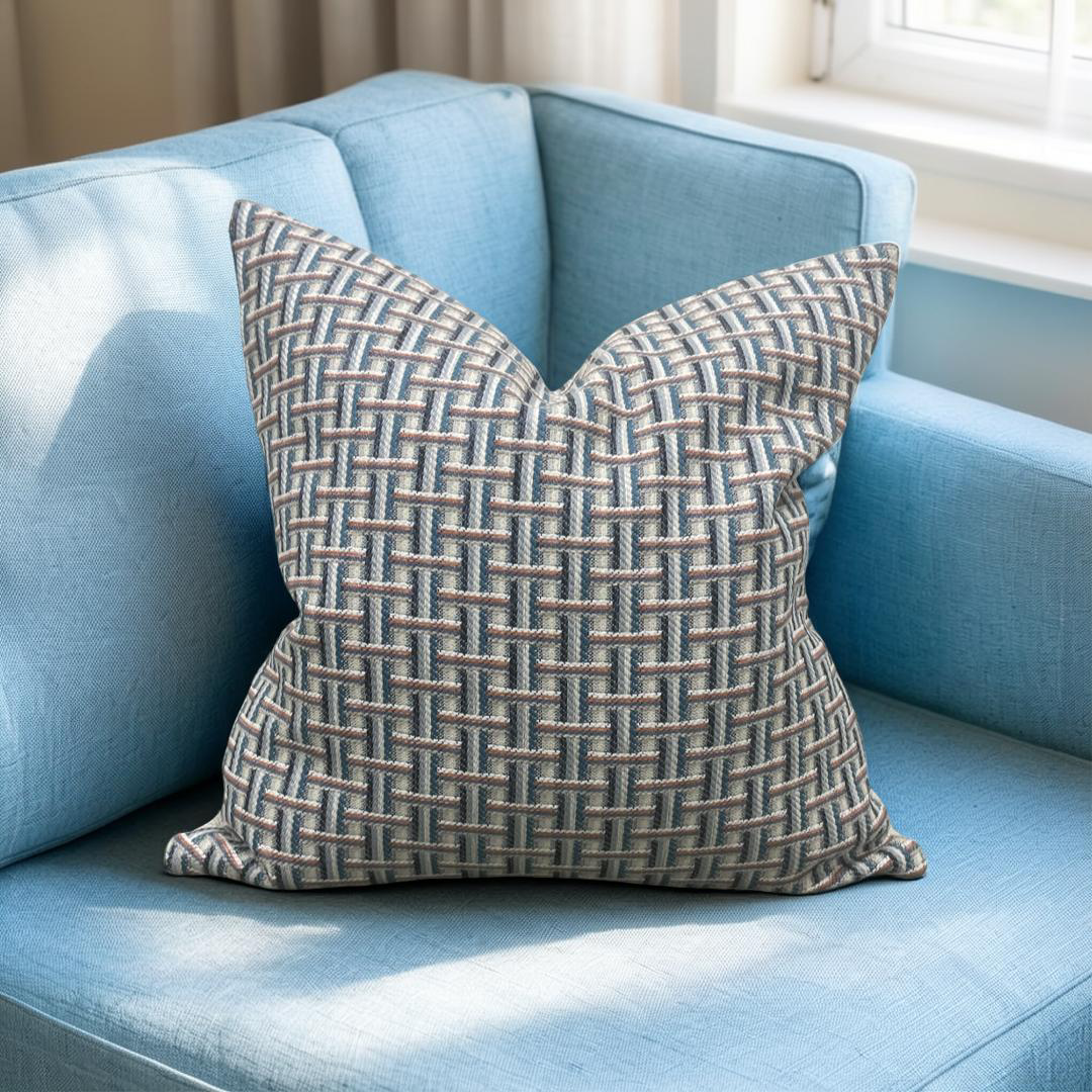 Patterned pillow on a light blue sofa with a neutral background