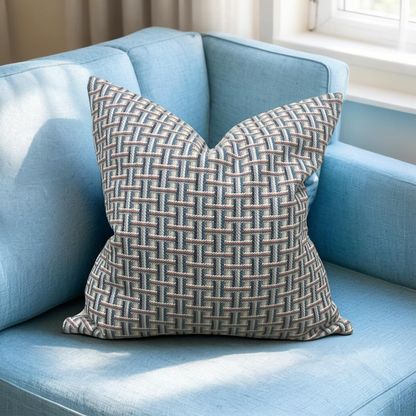 Patterned pillow on a light blue sofa with a neutral background