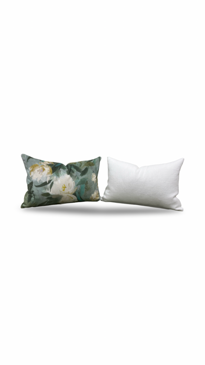 Decorative pillow with floral pattern and plain white pillow on a white background