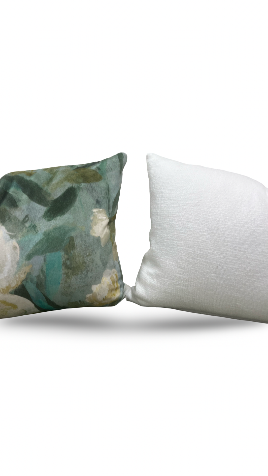 Decorative pillow with floral pattern next to a plain white pillow on a white background
