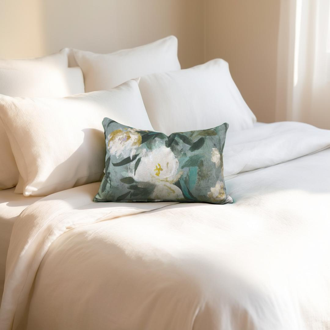 Floral pillow on a bed with white bedding
